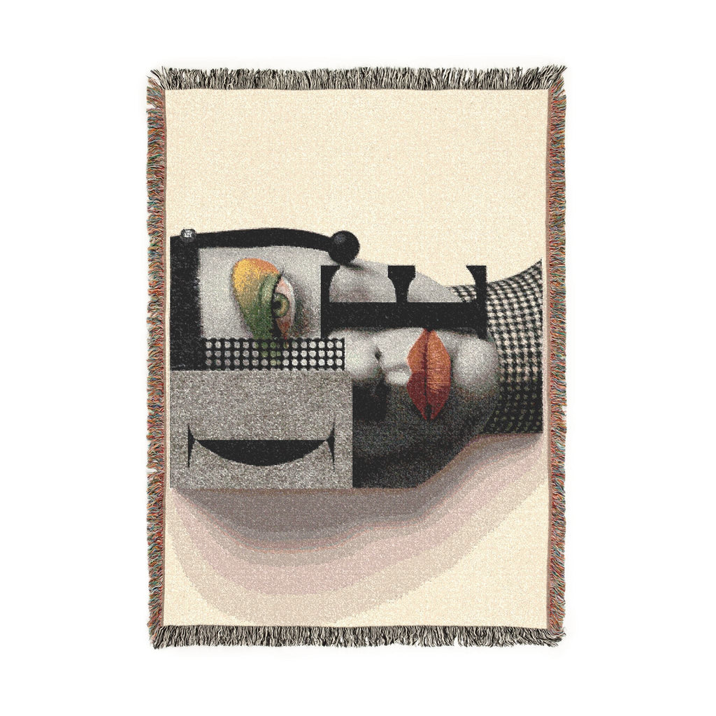 PURETE woven cotton throw blanket featuring a bold abstract portrait design with vibrant accents and fringed edges.