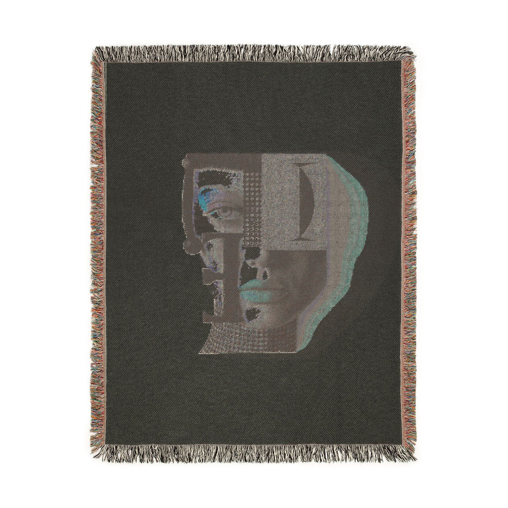 PURETE woven cotton throw blanket featuring a dark grey abstract portrait design with vibrant accents and fringed edges