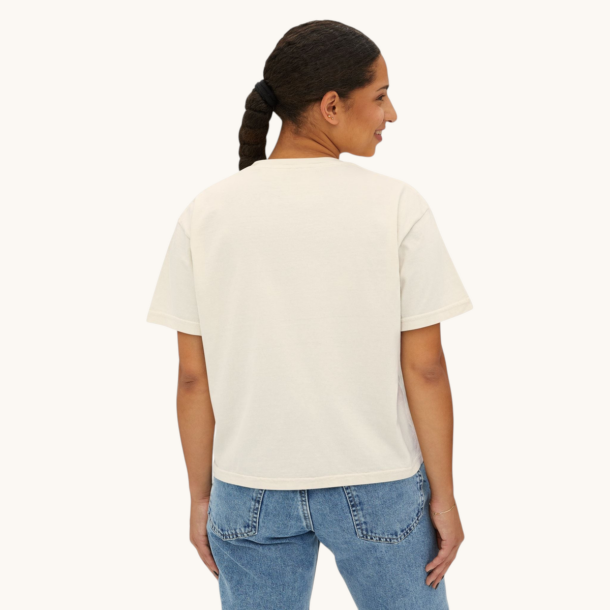 Model wearing a PURETE oversized cream boxy t-shirt in 100% cotton, back view against a plain white background.
