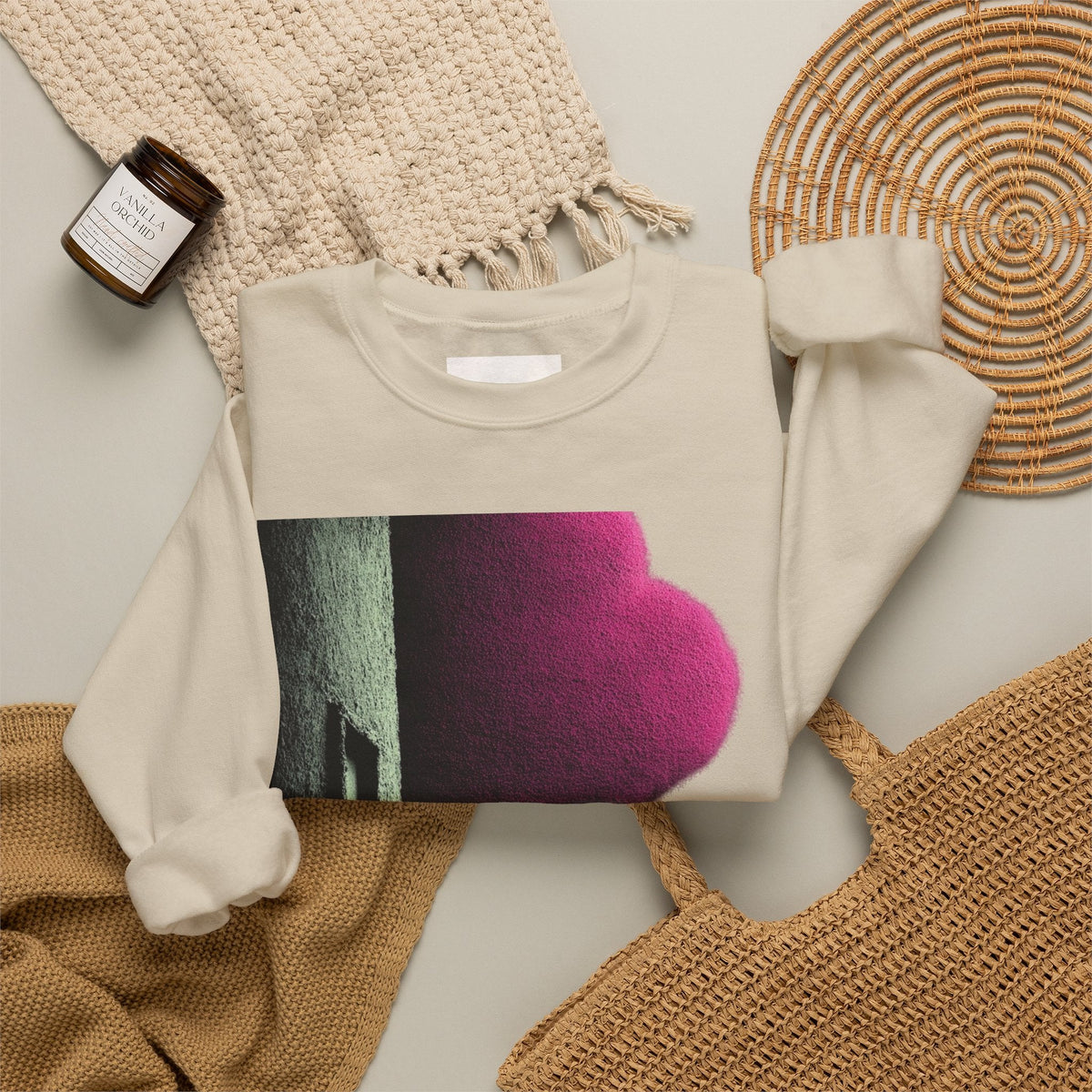 PURETE beige crewneck sweatshirt with a bold pink and black graphic print, styled on a neutral textured background.