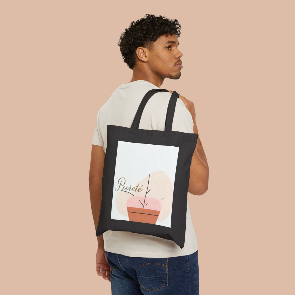 A man wearing a black PURETE cotton canvas tote bag with a minimalist plant illustration over his shoulder.