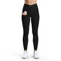 PURETE high-rise black yoga leggings with a cross-front waistband and a small floral heart graphic on the hip.