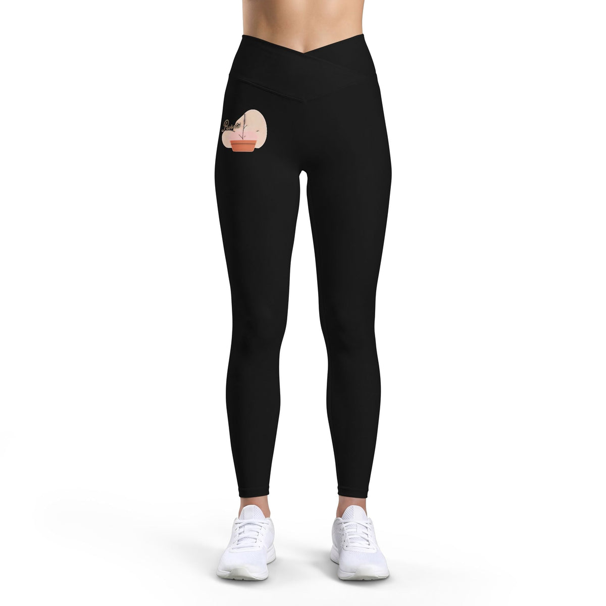 PURETE high-rise black yoga leggings with a cross-front waistband and a small floral heart graphic on the hip.