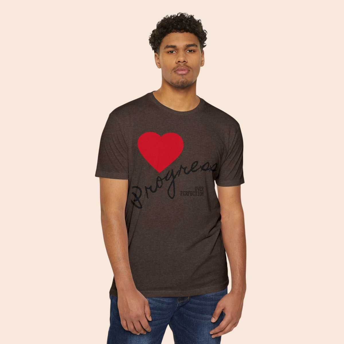 A man wearing a PURETE dark brown cotton-blend t-shirt featuring a red heart and Progress Over Perfection text.