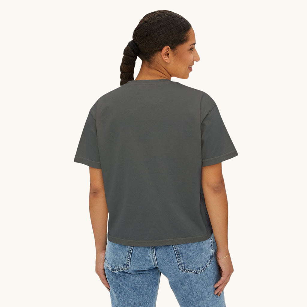 A woman wearing a PURETE charcoal grey oversized boxy cotton t-shirt, back view, paired with blue denim jeans.
