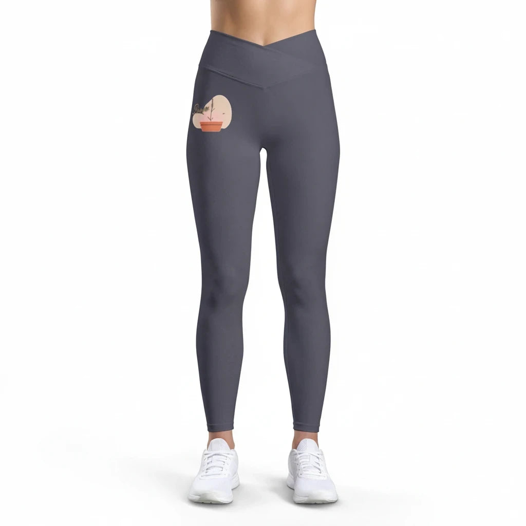 PURETE high-rise charcoal grey yoga leggings with a cross-front waistband and a small floral heart hip graphic.
