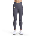 PURETE high-waist charcoal grey yoga leggings with a v-cut waistband and subtle logo, worn by a model in white sneakers.