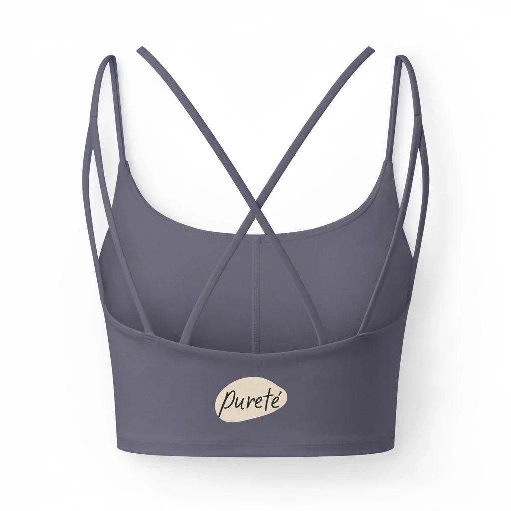 PURETE luxe crop sports bra in dark grey with slim crisscross back straps and a minimalist botanical hem graphic
