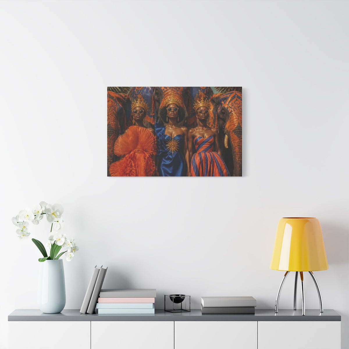 PURETE matte canvas print featuring three women in ornate crowns and vibrant dresses hanging on a white wall.