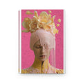 PURETE hardcover journal featuring a surreal portrait of a woman with floral headpiece and dripping pink paint.