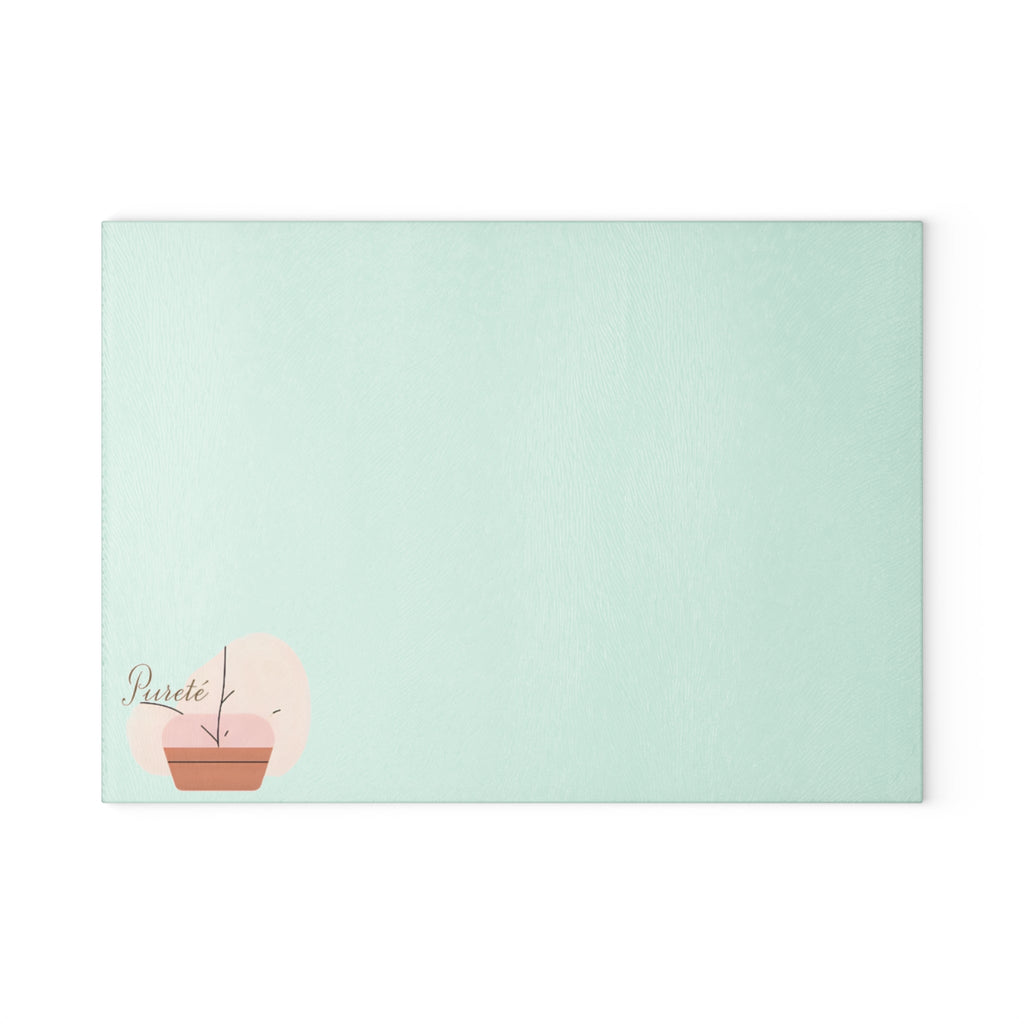 PURETE tempered glass cutting board in light mint green with a minimalist potted plant logo in the corner