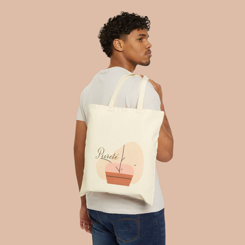 A man wearing a PURETE natural cotton canvas tote bag with a minimalist plant graphic over his shoulder