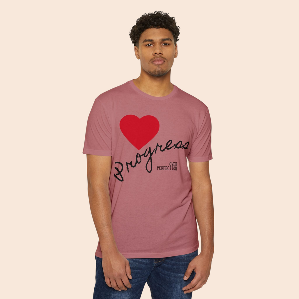 A man wearing a PURETE mauve cotton-blend t-shirt featuring a red heart and Progress Over Perfection graphic.