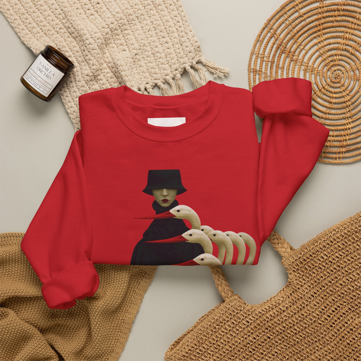 PURETE red crewneck sweatshirt featuring a surreal graphic of a figure in a black hat with multiple white bird heads.