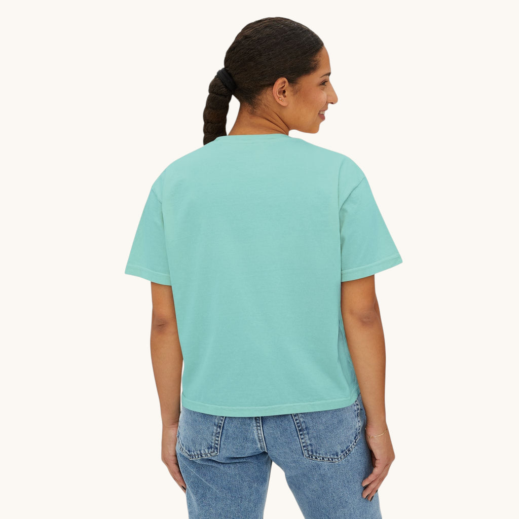 A woman wearing a PURETE oversized boxy t-shirt in light teal cotton, viewed from the back against a white background.