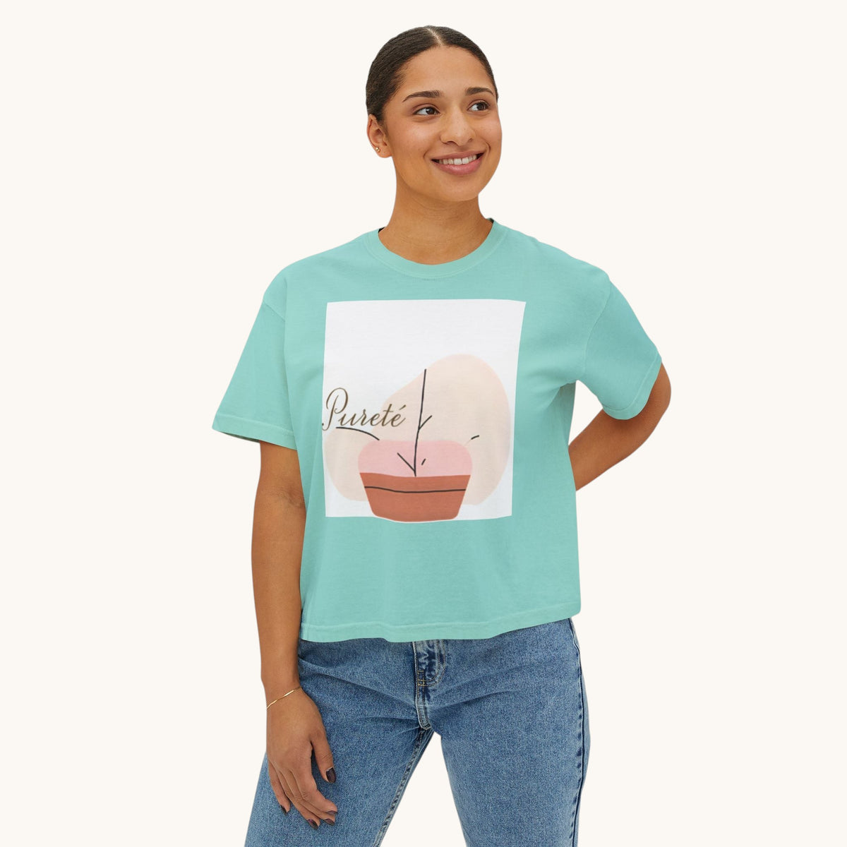 A woman wearing a PURETE oversized teal boxy cotton t-shirt with a minimalist abstract graphic print.