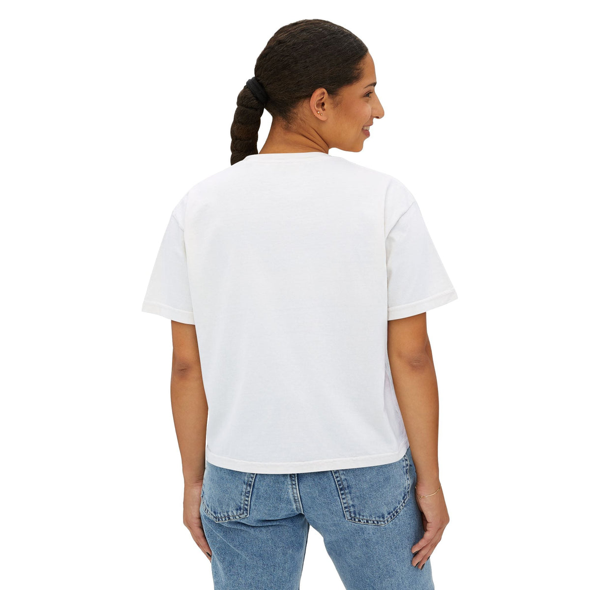 Back view of a woman wearing a PURETE white boxy cotton t-shirt with a relaxed, cropped fit and blue jeans.