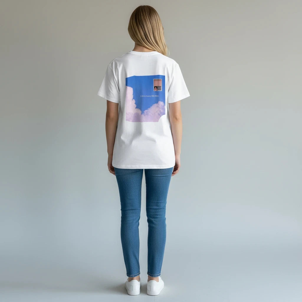 Woman wearing a PURETE white cotton t-shirt with a dreamy cloud and window graphic print on the back.